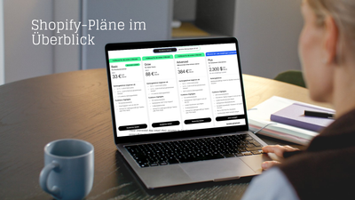 Person sitzt an einem Tisch und betrachtet auf einem Laptopbildschirm eine Übersicht der Shopify-Pläne mit den Kategorien Basic, Grow, Advanced und Plus