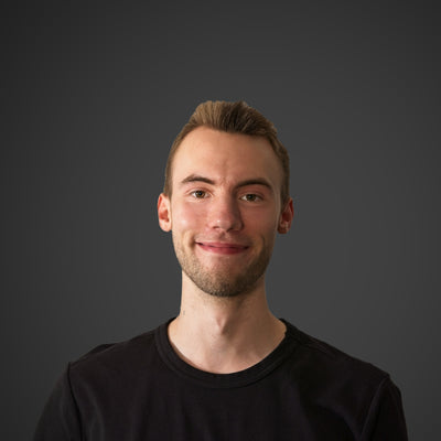 Junger Mann mit einem freundlichen Lächeln, kurzen blonden Haaren und schwarzem T-Shirt mit der Aufschrift "shopnative".